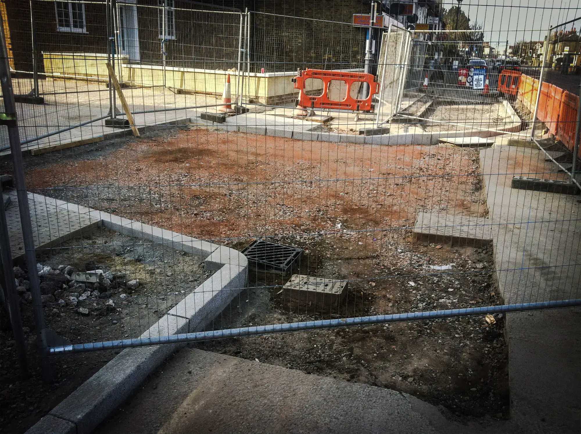 Kerbed pavement works behind fencing