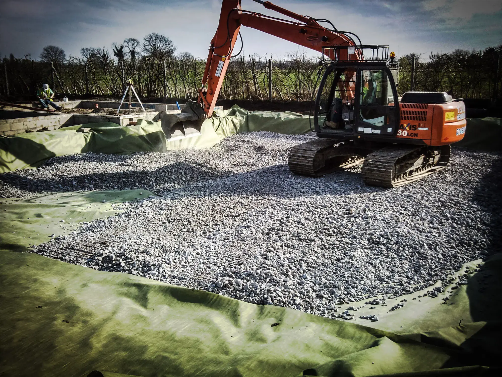 Excavator placing stone sub-base